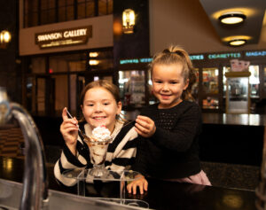 Two kids enjoying an ice cream sundae