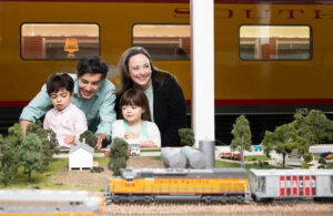 A family checks out the model train set